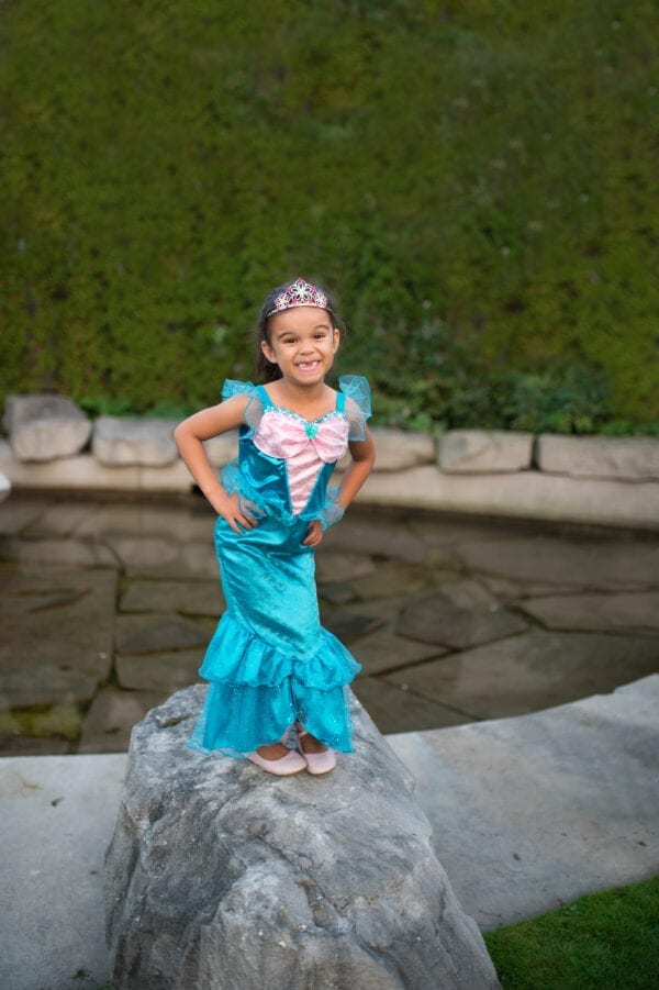 Meisje met blauwe zeemeermin jurk. Het is een zeemeerminnenjurk met een roze satijnen top. Heeft glitter schubben op de rok en is afgewerkt met organza.